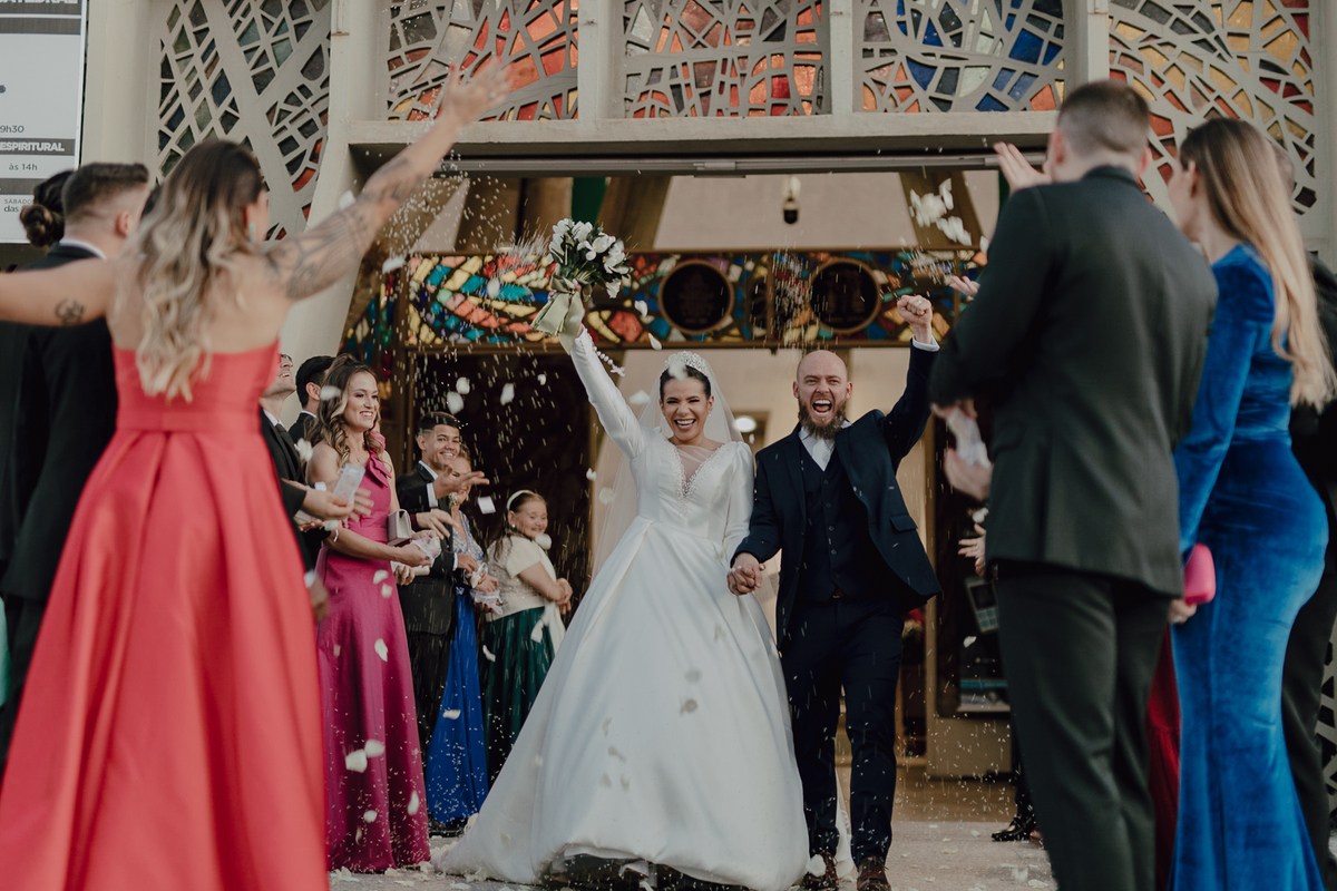 Saída dos noivos com pétalas de flores em casamento na igreja Catedral de Maringá