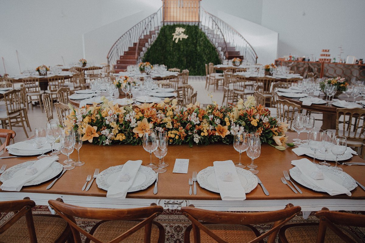 Mesa dos convidados com flores laranjas 