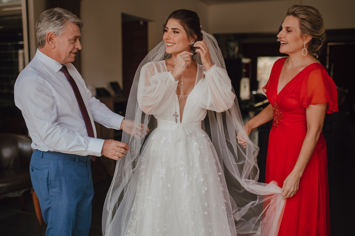 Pais da noiva ajudando ela antes de irem para igreja 