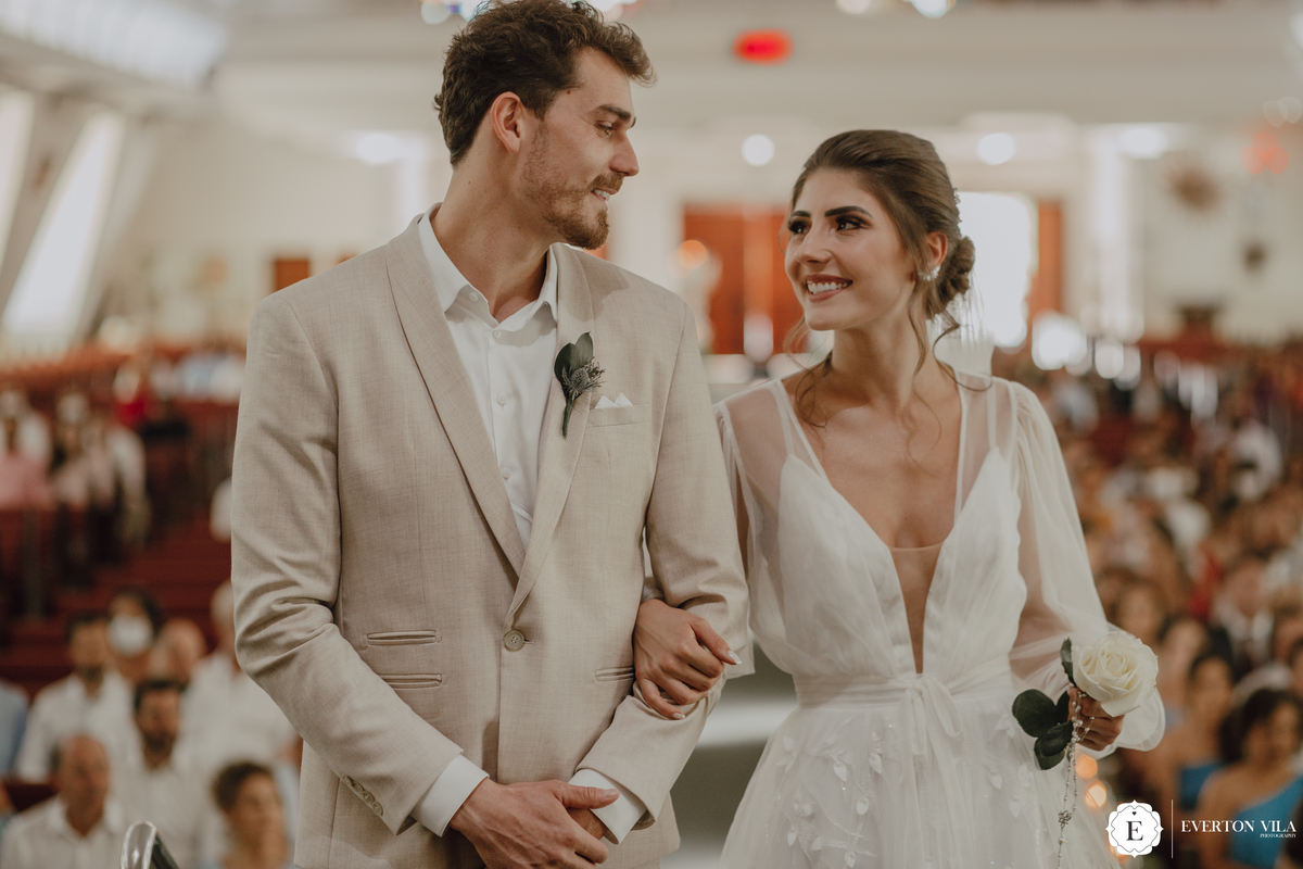 Troca de olhares entre a  noiva e o noivo em casamento na igreja 