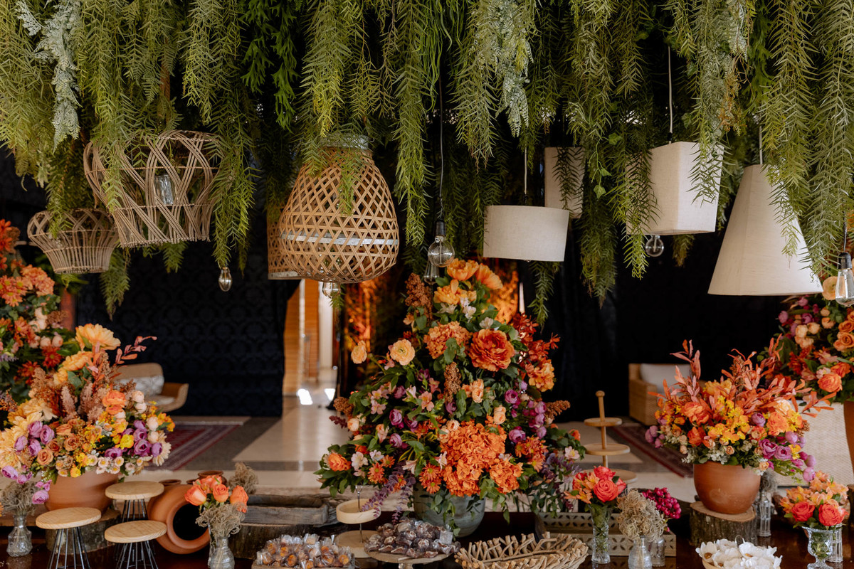 Mesa de doces com flores laranjas 