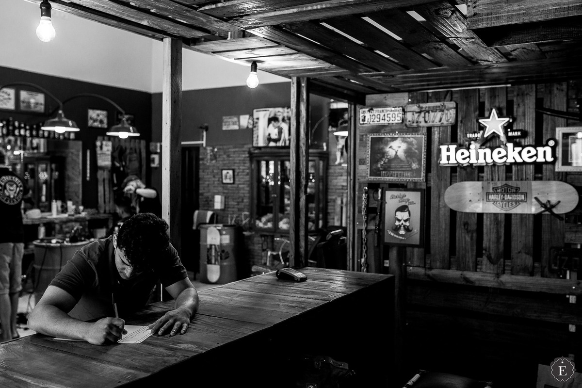 noivo escrevendo os votos do casamento na barbearia