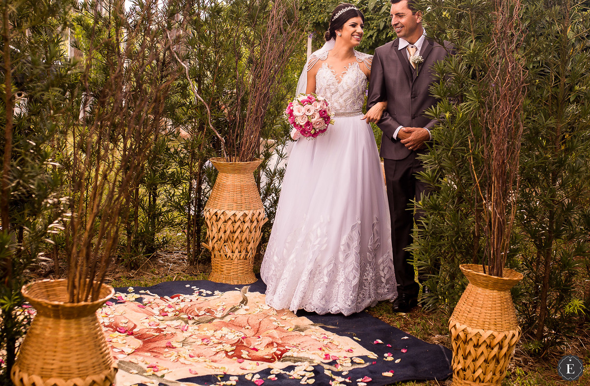 noiva sorrindo com o pai na entrada do casamento no campo