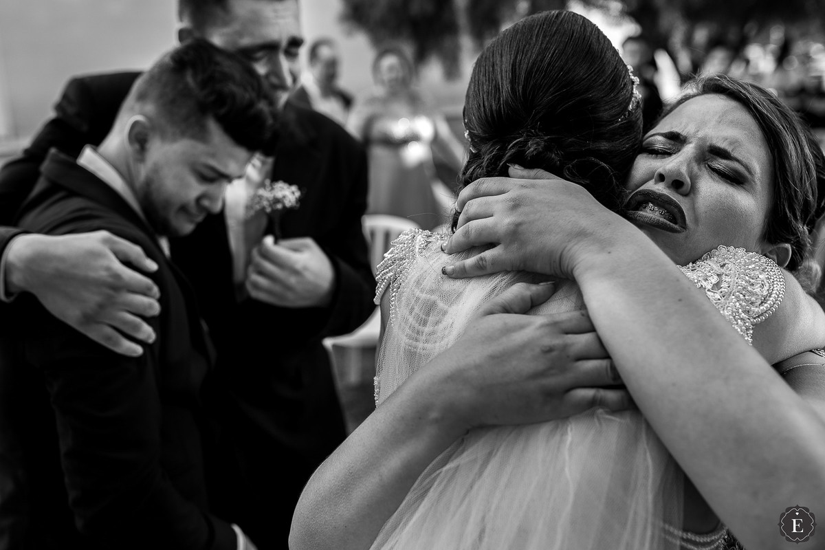 casal de padrinhos abraçando os noivos no final da cerimônia