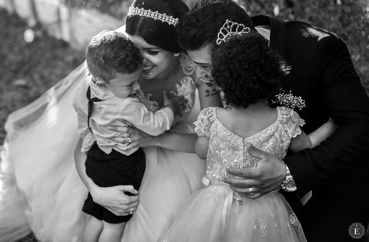 noivo e noiva abraçando as crianças que entraram com as alianças