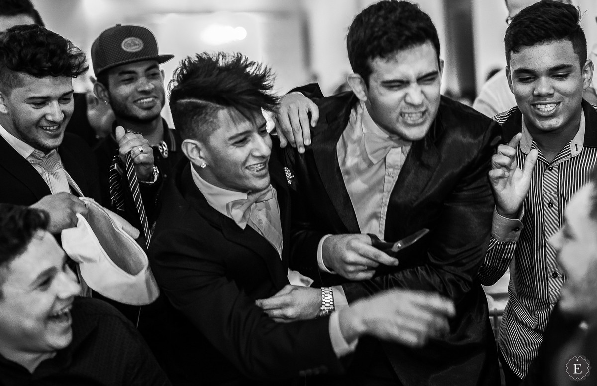 padrinhos do casamento brincando no corte da gravata do noivo