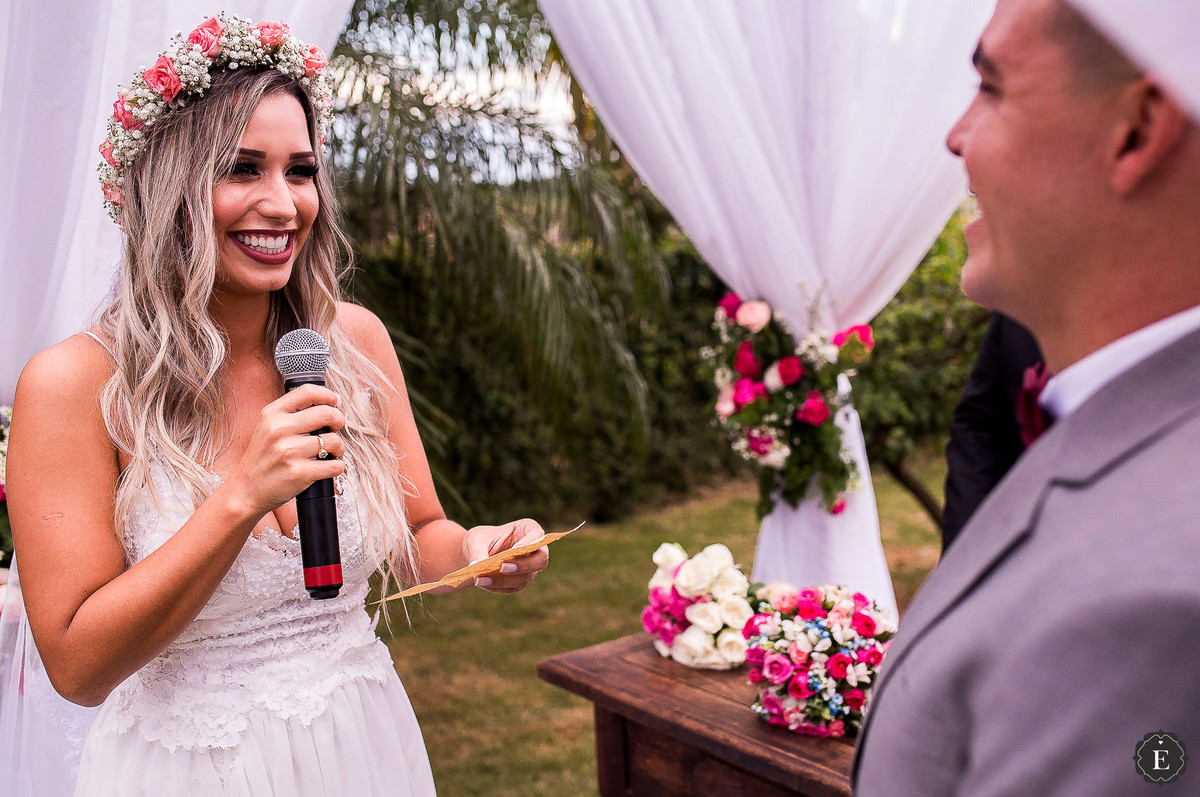 noiva lendo seus votos para o noivo na cerimonia ao ar livre