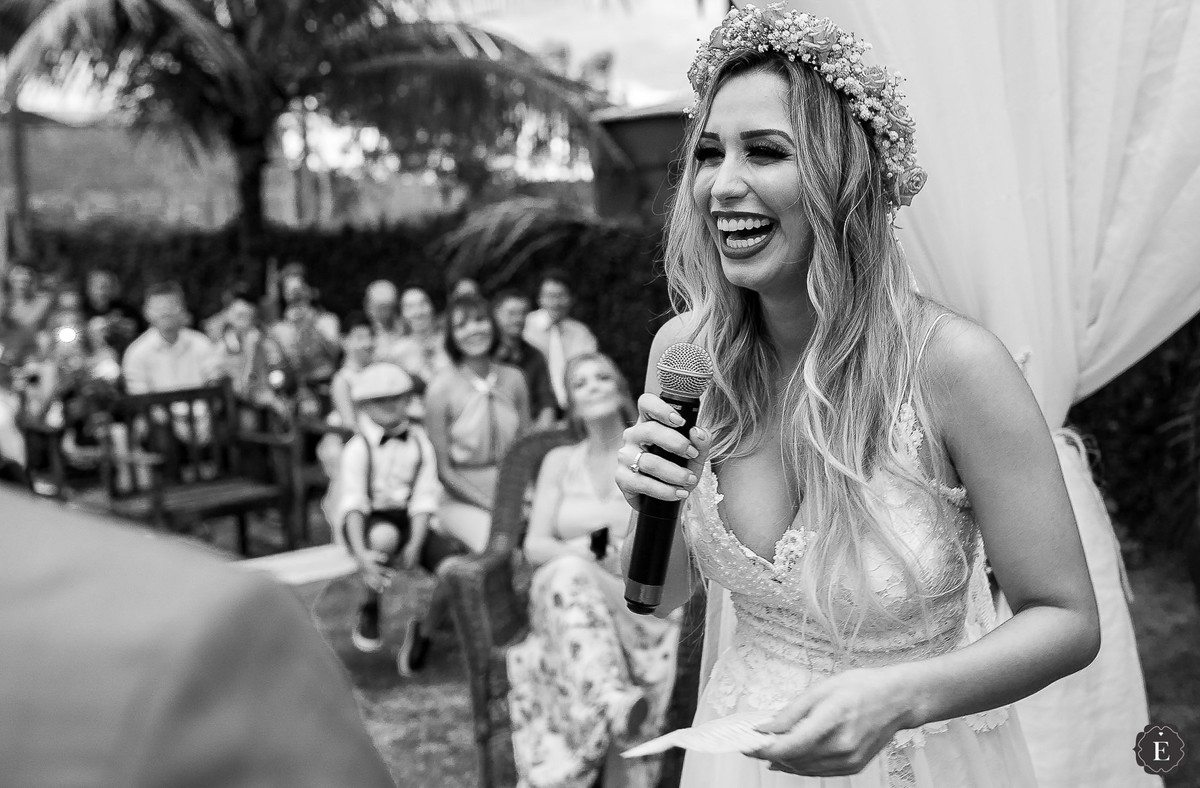 noiva de cabelo solto feliz ao ler os votos de casamento