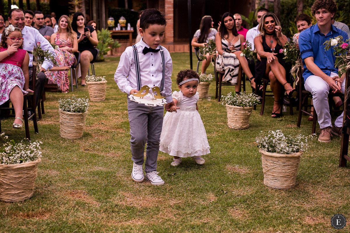 pajem de gravata borboleta e daminha com vestido de renda levando as alianças
