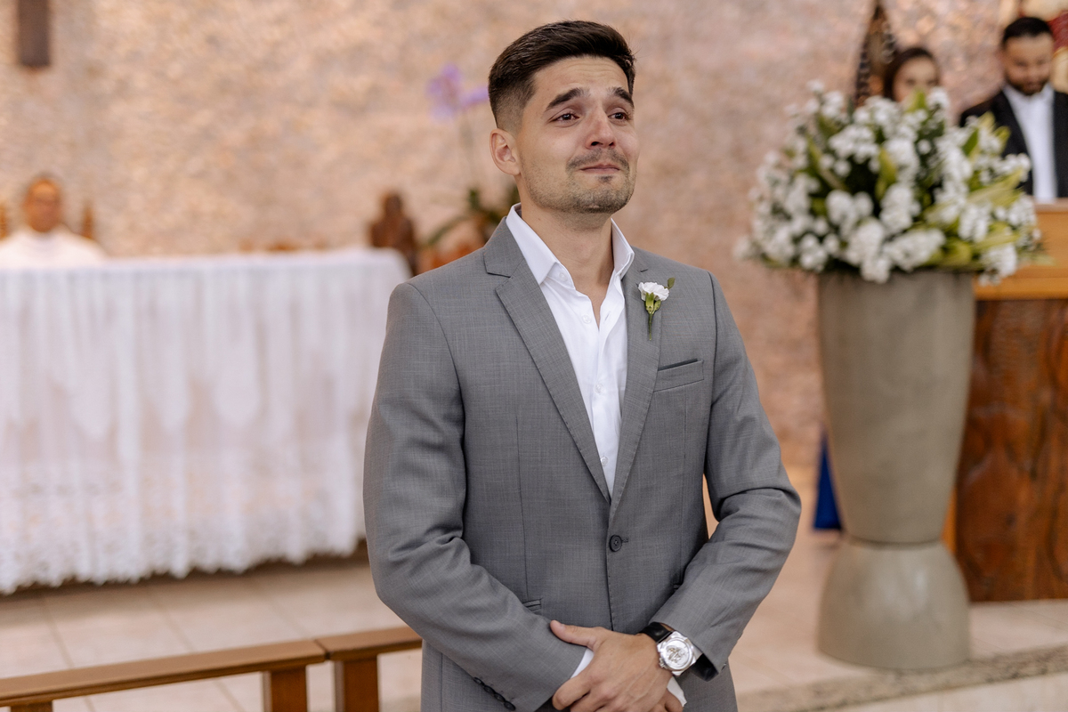 Noivo emocionado ao ver sua noiva entrando na igreja