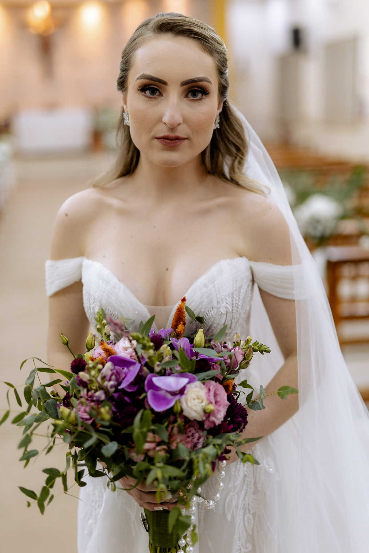 Noiva com buquê de flores na cor roxa