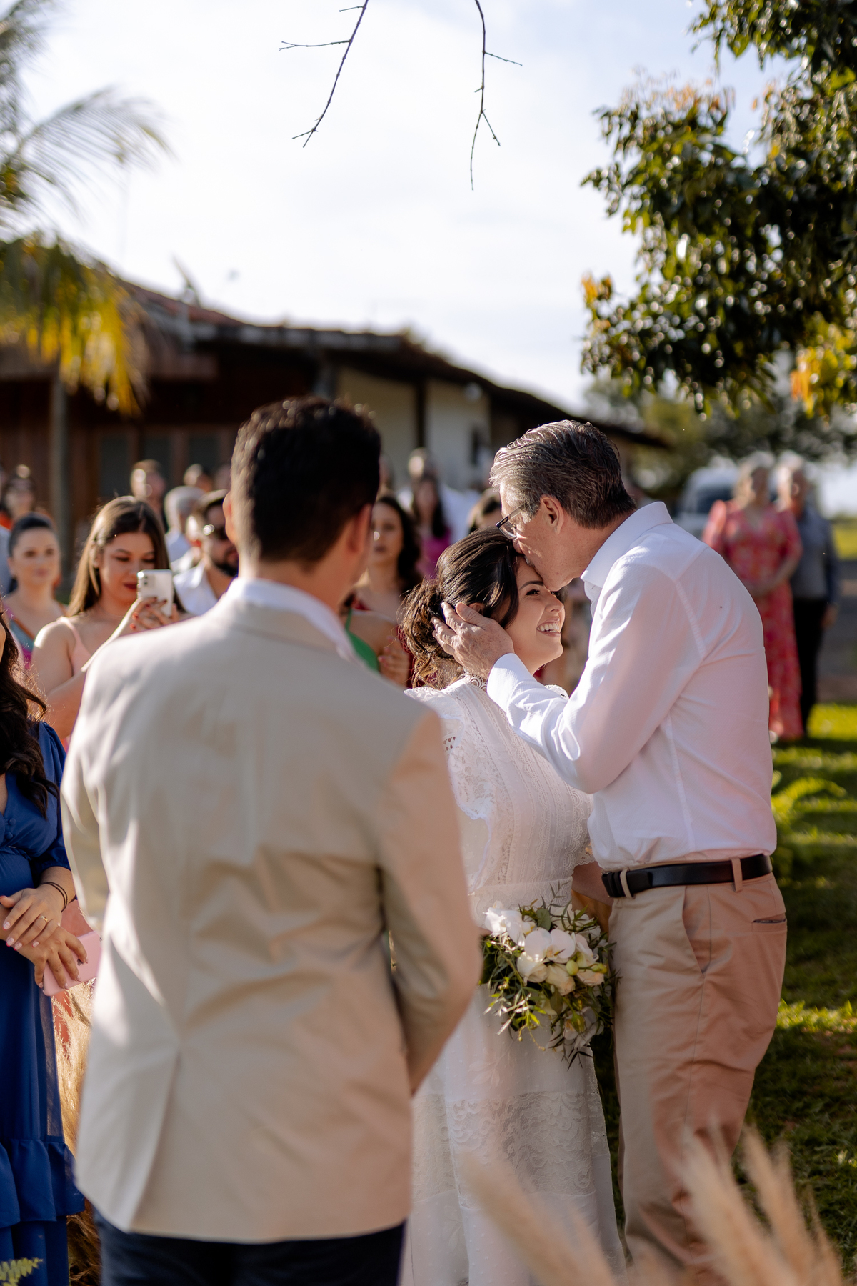 Pai da noiva beijando sua testa na entrada