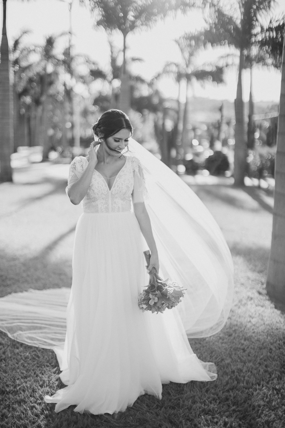 Noiva com cabelo em coque despojado e vestido com decote V e fluido