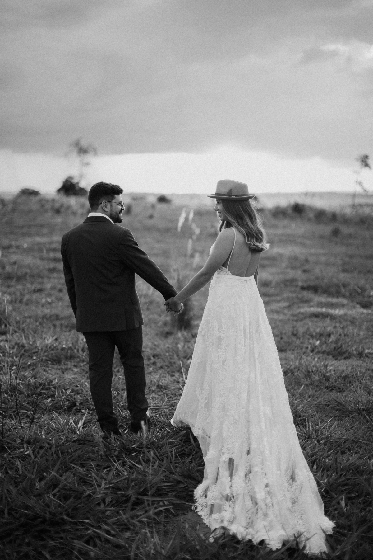 Casal de mãos dadas em ensaio no campo 