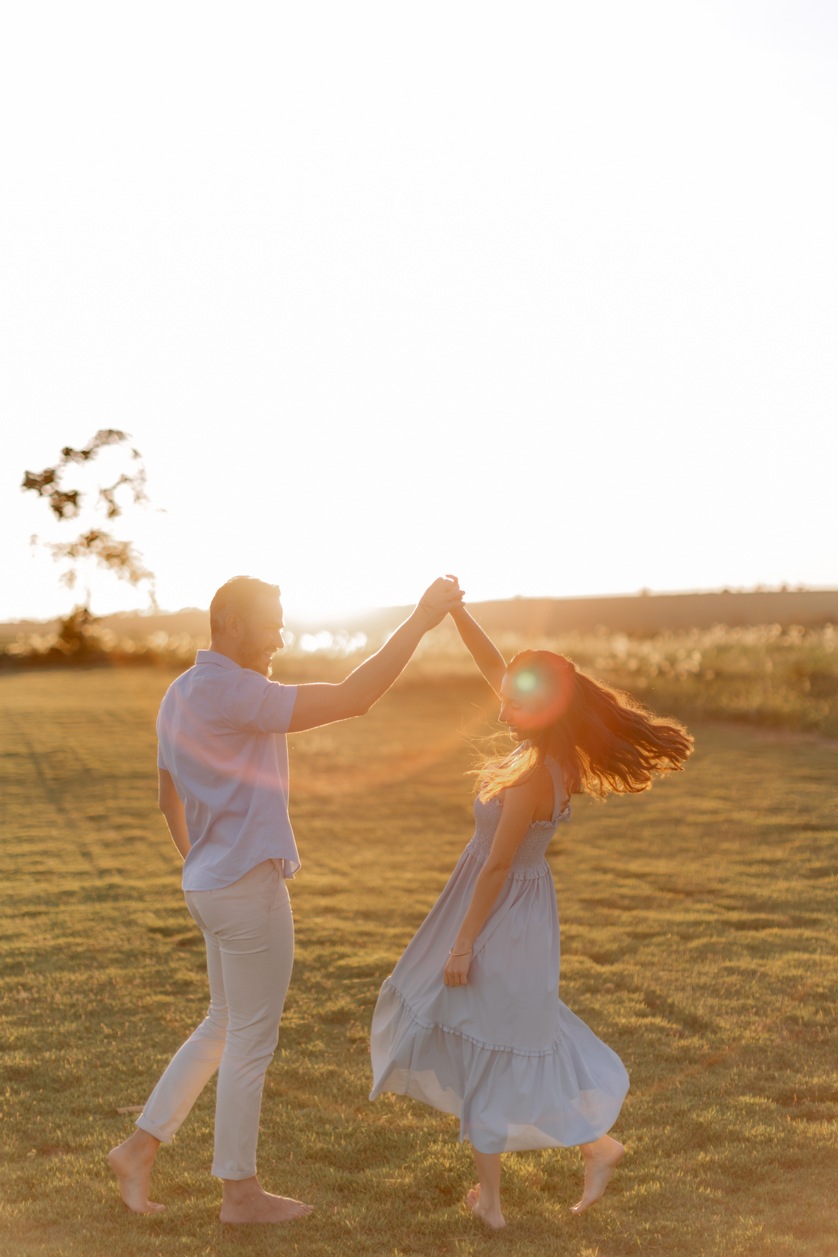 Casal dançando no campo com por do sol