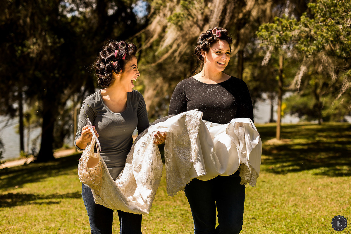 noiva e madrinha com vestido de noiva no campo