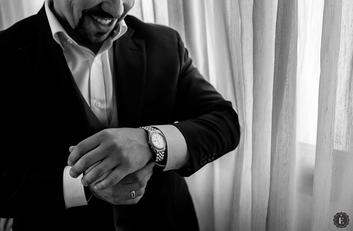 noivo no hotel colando relógio de seu pai para o casamento