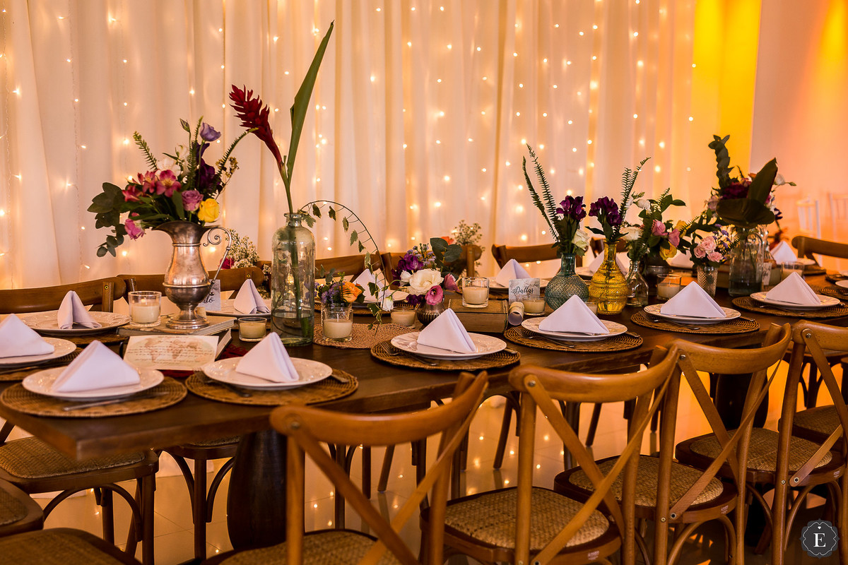 mesa comunitária para a família no casamento com cortina de luzes e decoraçao vintage