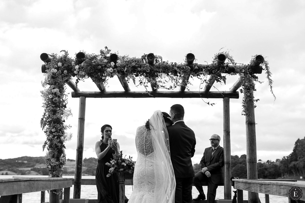 irma da noiva cantando no pergolado de madeira com flores
