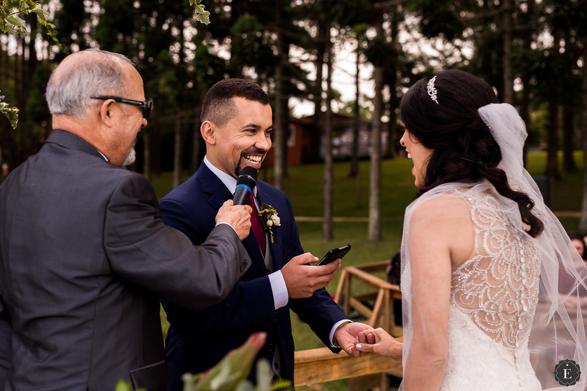noivo lendo seus votos para a noiva em casamento ao ar livre