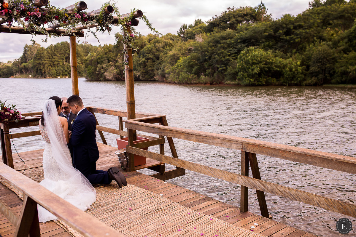 noivos orando no pergolado de madeira em casamento sobre o rio em curitiba