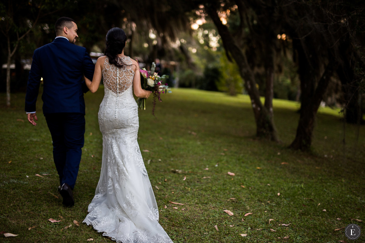 noivo com terno azul e noiva com seu vestido de noiva com detalhe nas costas