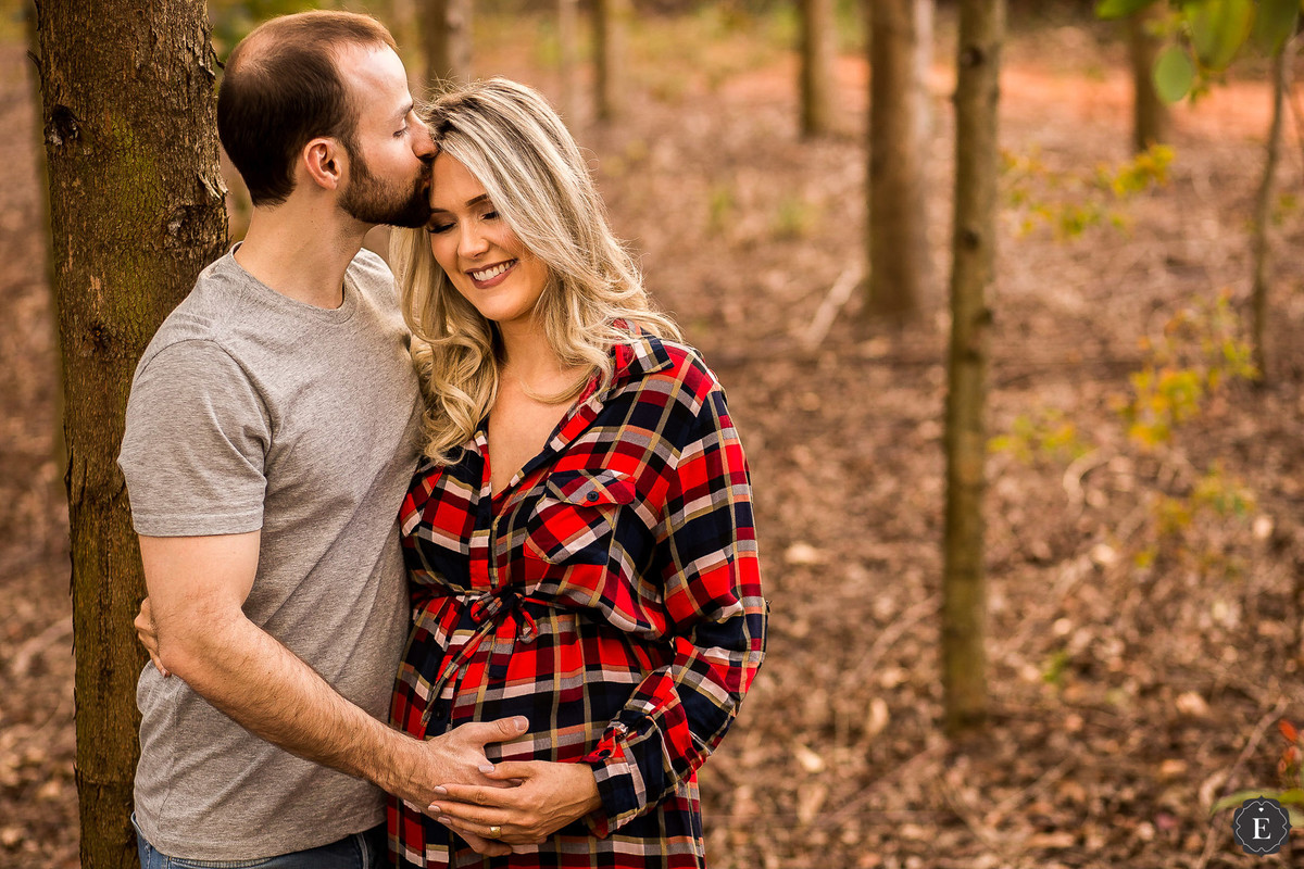 pai beijando esposa gestante em fotos ao ar livre