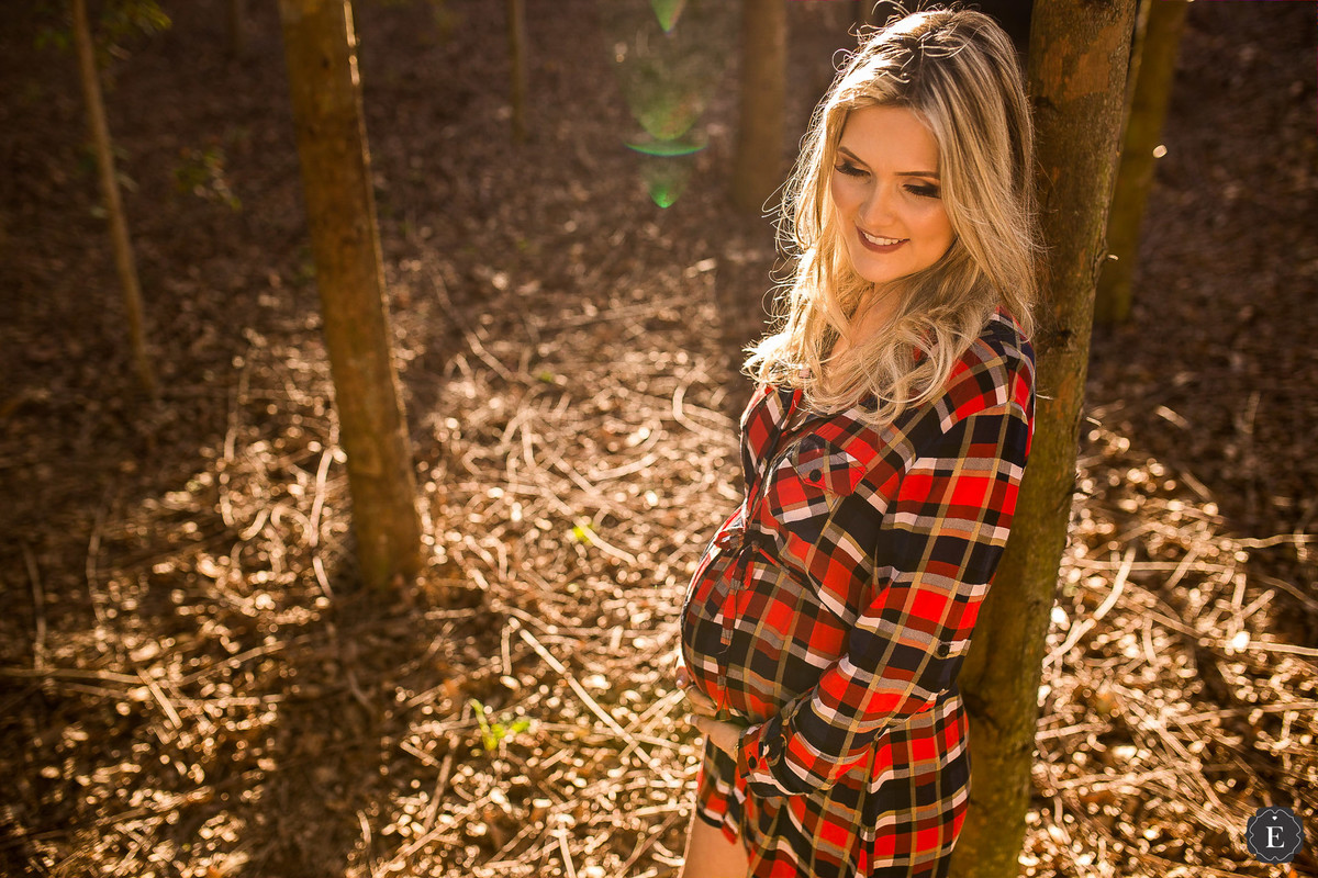 gestante com roupa xadrez em ensaio ao ar livre