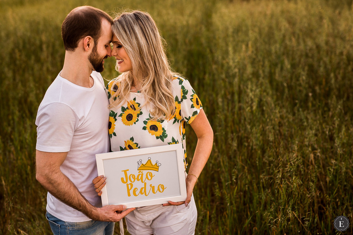 casal feliz com quadro personalizado com nome de seu filho joao pedro em fotos de gestante criativas