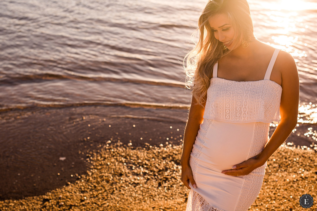 mae de menino em ensaio de fotos na praia com vestido branco