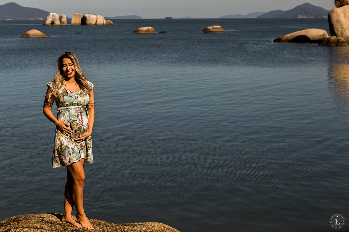 gestante com vestido estampa em fotos na praia