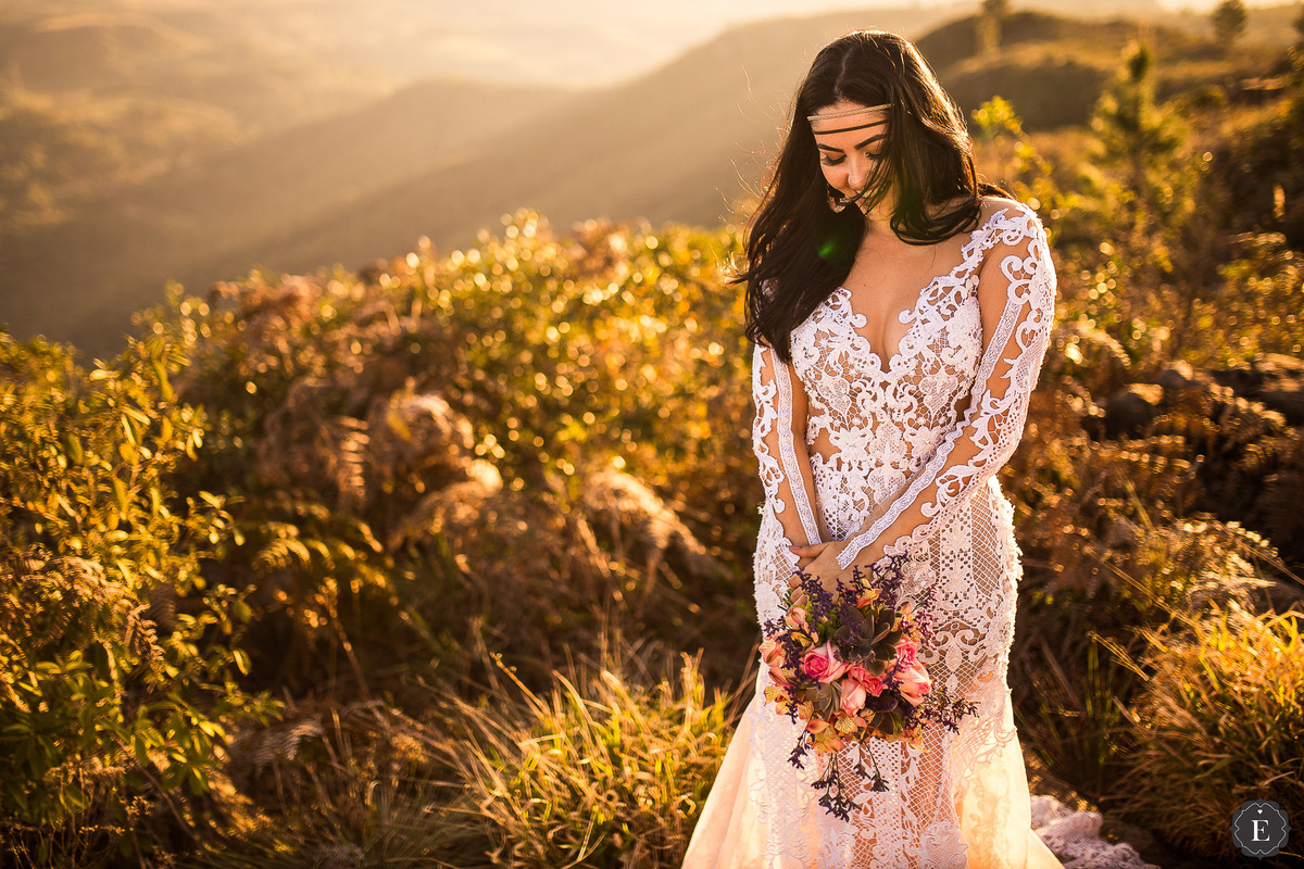 noiva boho com vestido de renda e head band no cabelo em fotos na montanha