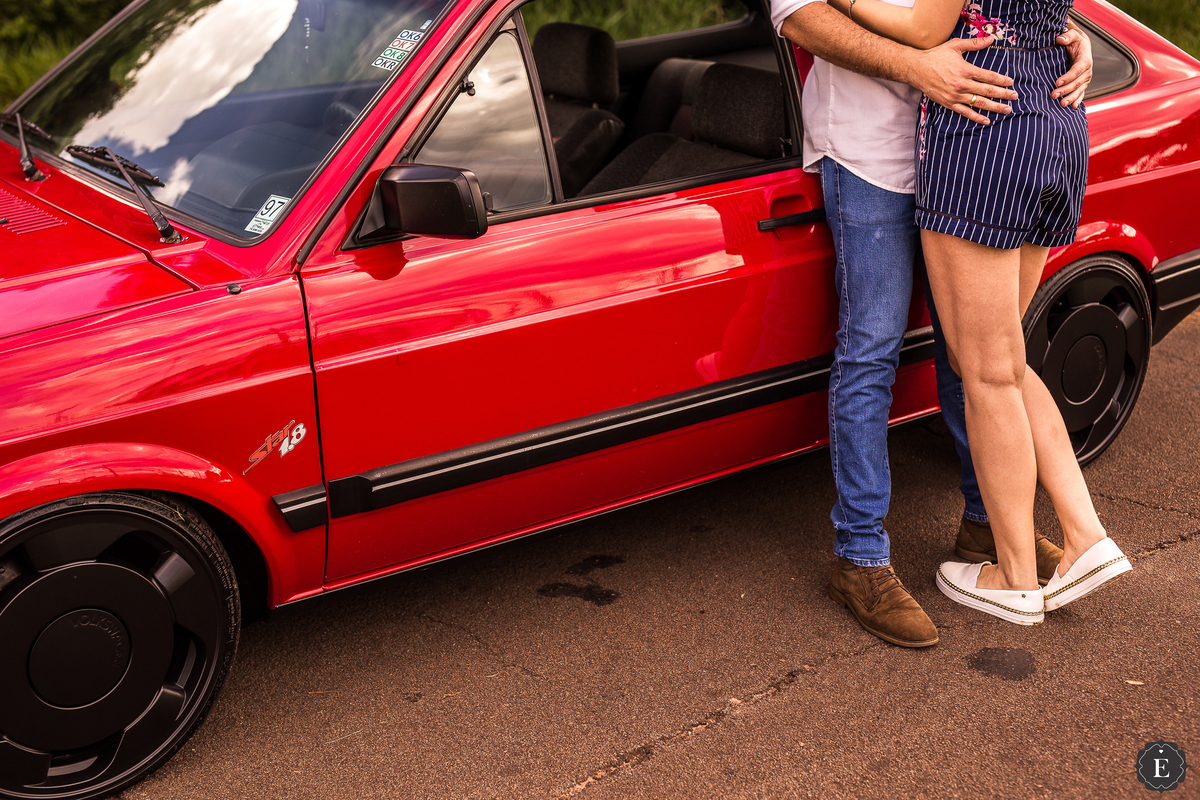 noivo e noiva em ensaio de fotos diferente com carro vermelho