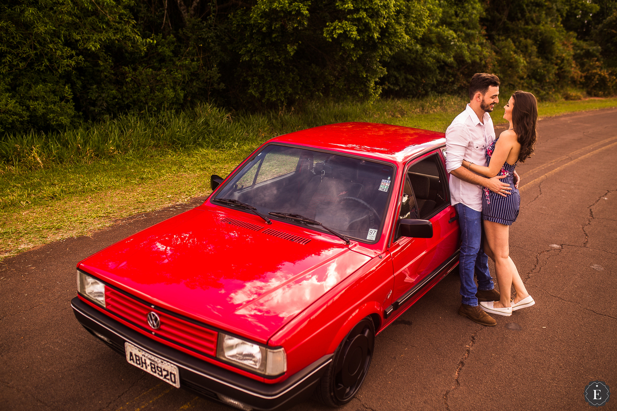 noiva de macacão e noivo de camisa branca em ensaio de fotos com carro no parana