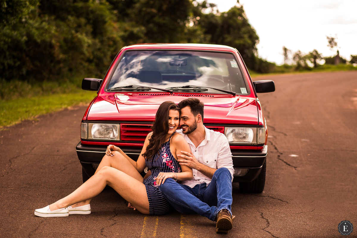 casal sentado ao lado do carro em fotos criativas do pre casamento