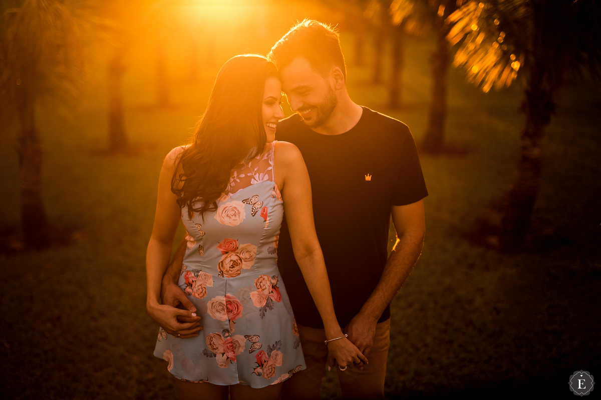 noiva com vestido florido ao lado de seu noivo em ensaio de fotos de casal