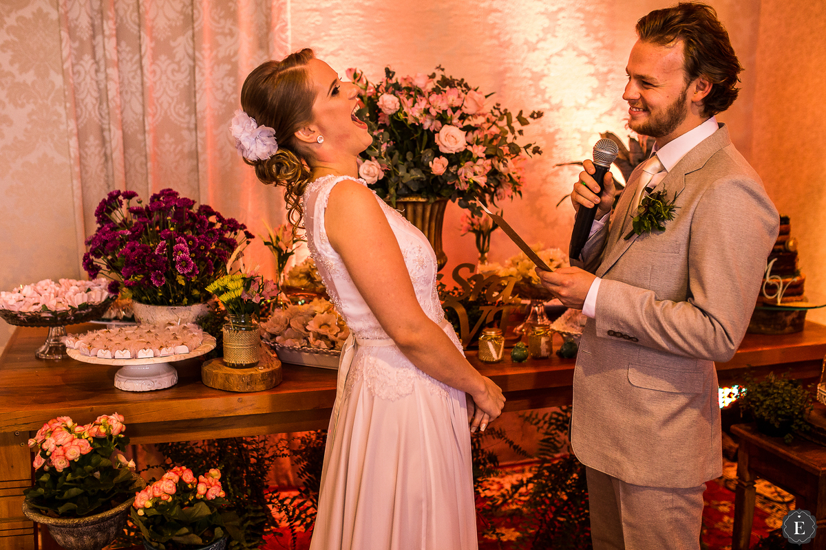 noivo com terno retro cinza claro lendo os votos para noiva de vestido delicado em seu casamento de dia em maringa