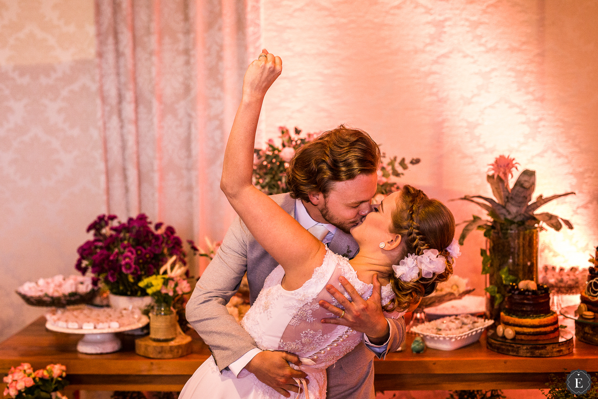 noiva com cabelo preso de coque com traças e arranjo de flores delicado 