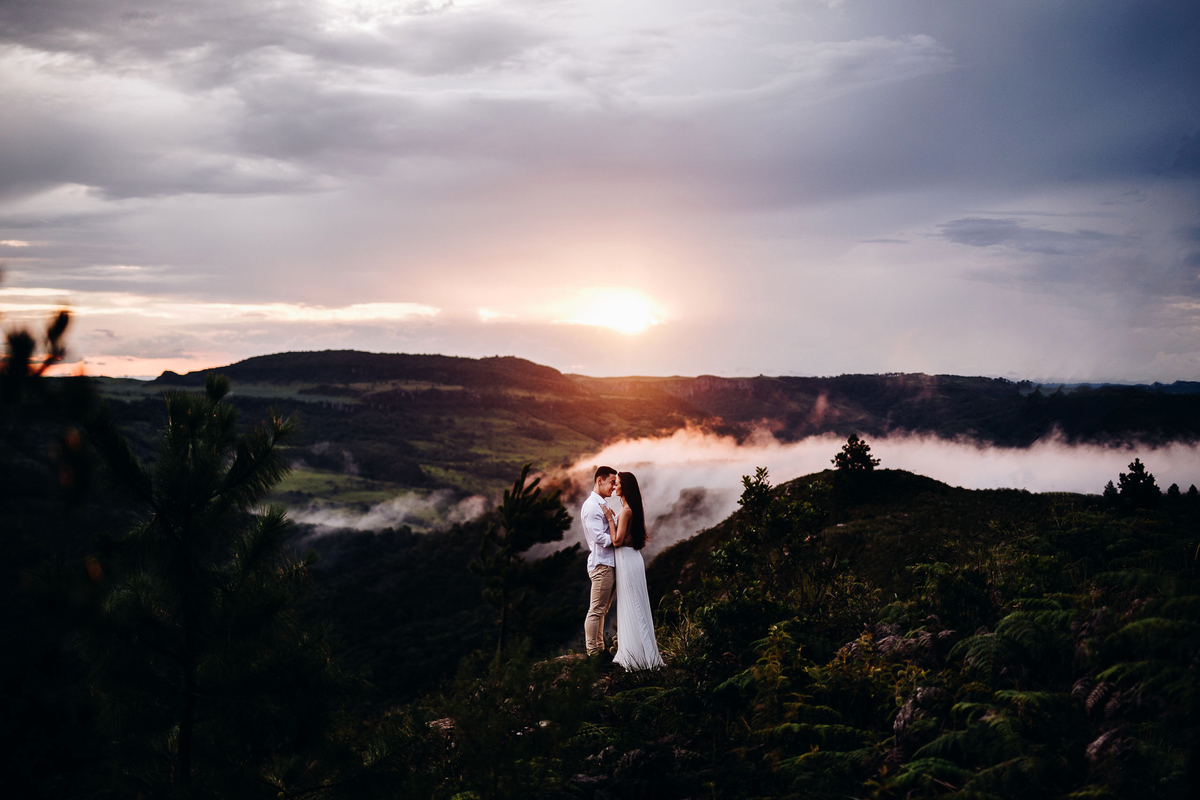 casal em fotos criativas nas montanhas com neblina do ensaio pre casamento em maua da serra