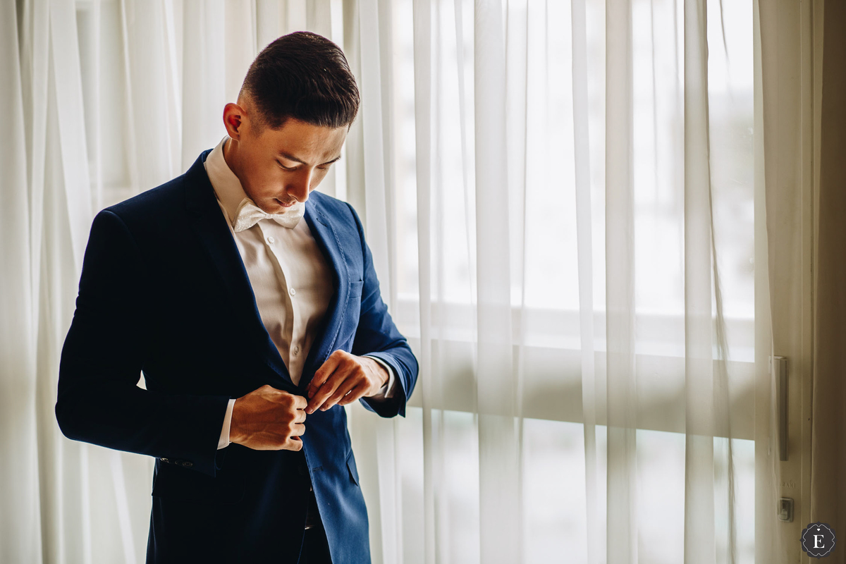 noivo estiloso com terno azul marinho e gravata branca no hotel em cianorte