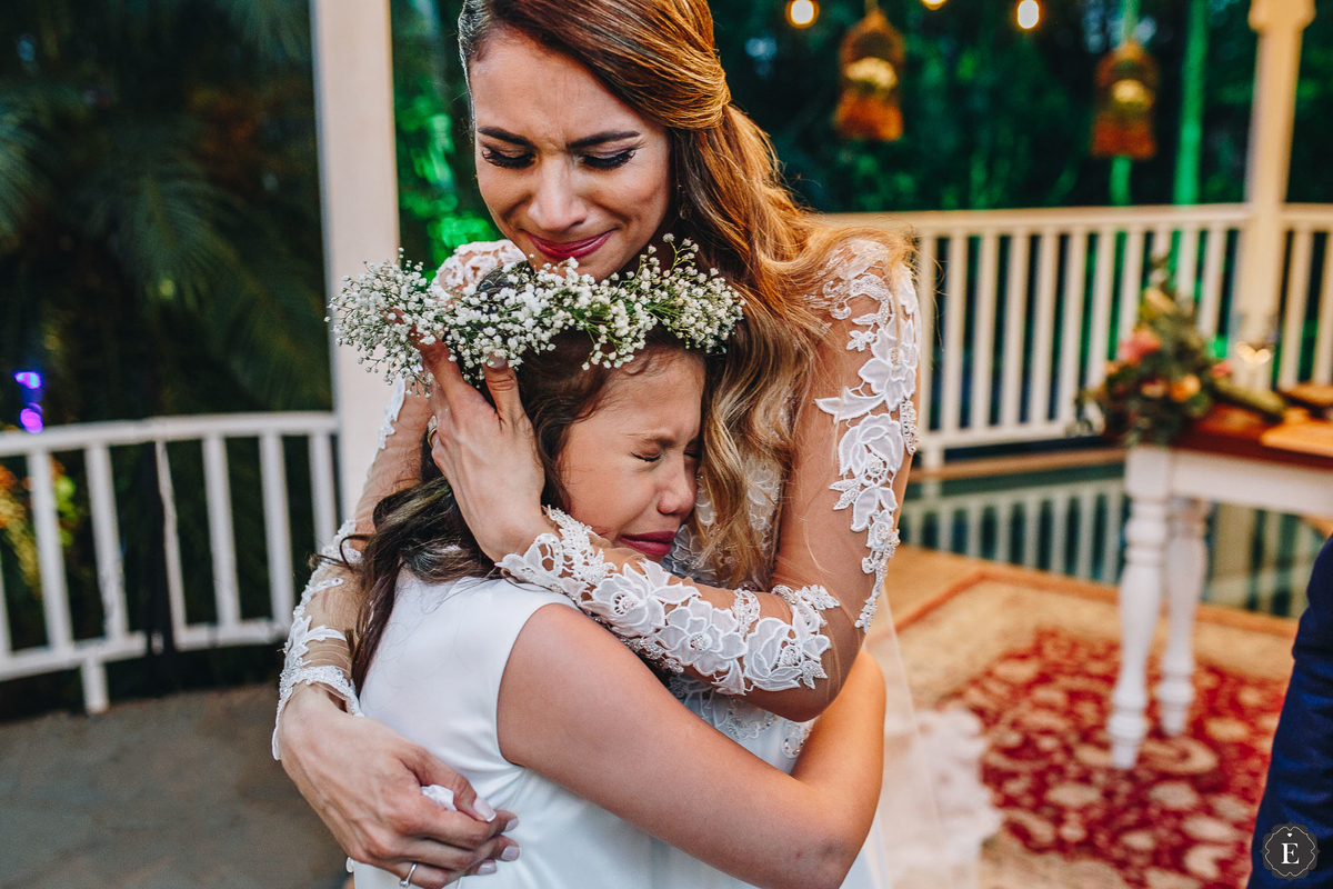 noiva emocionada com daminha de honra com coroa de flores