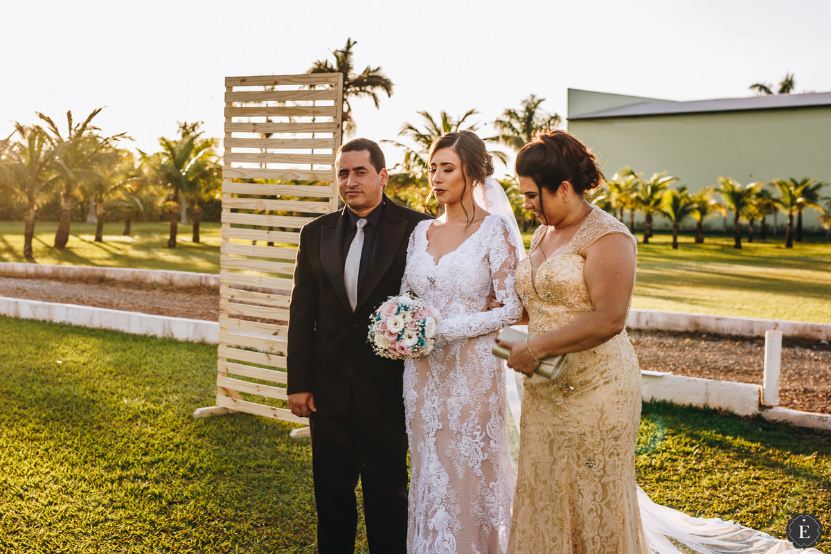 noiva emocionada na sua entrada com seu pai e sua mae