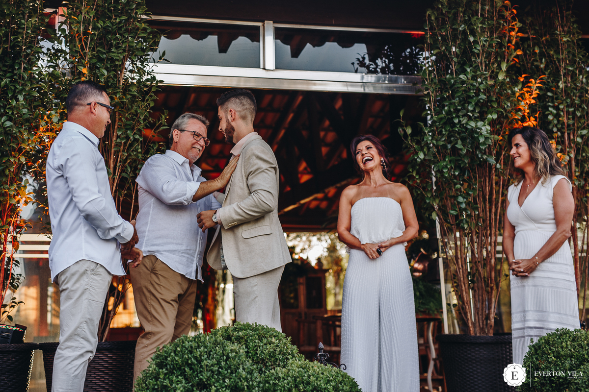 noivo cumprimentando seu pai junto a sua mãe e aos pais da noiva