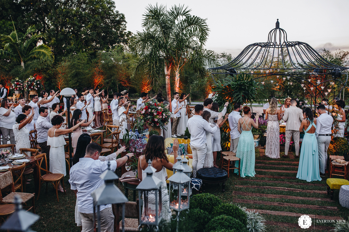 convidados estendendo as mãos aos noivos como forma de proteção e amor a eles