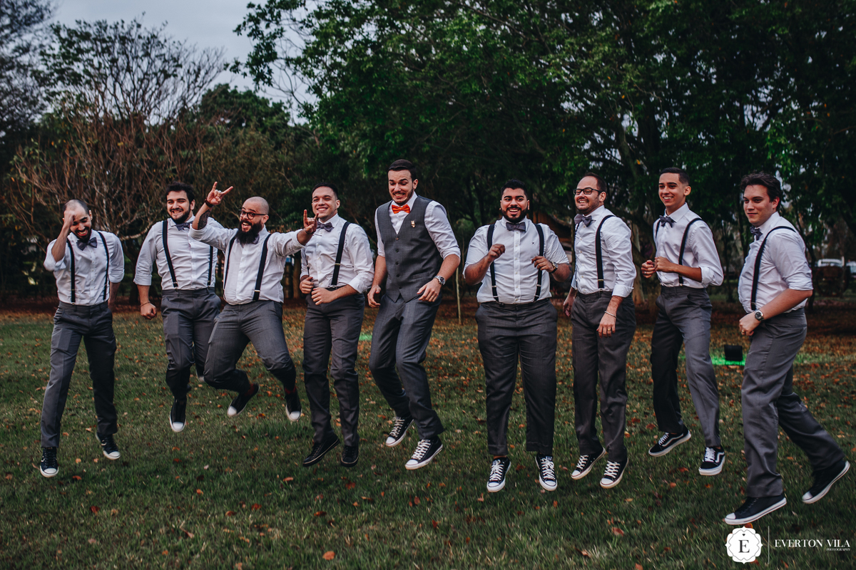 noivo com padrinhos de terno cinza, suspensório, gravata borboleta e all star em casamento criativo no campo