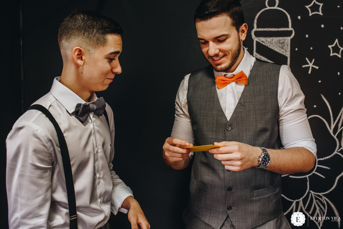 noivo com colete cinza e gravata borboleta laranja para seu casamento ao ar livre