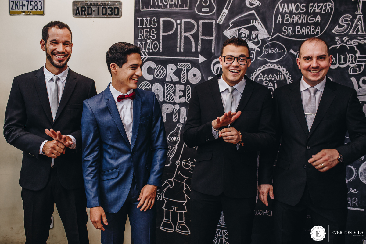 noivo com seus padrinhos de terno preto e gravata clássica para casamento externo de dia