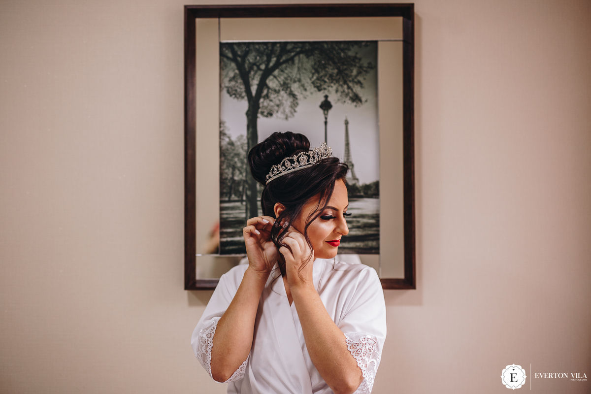 noiva feliz com coque alto e coroa em seu penteado de noiva