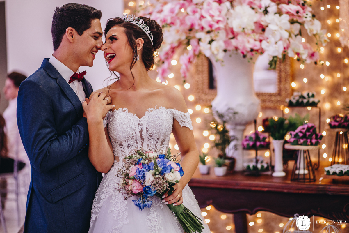 noivos sorrindo em frente a mesa de doces em seu casamento na chácara vale dos sonhos em cianorte paraná
