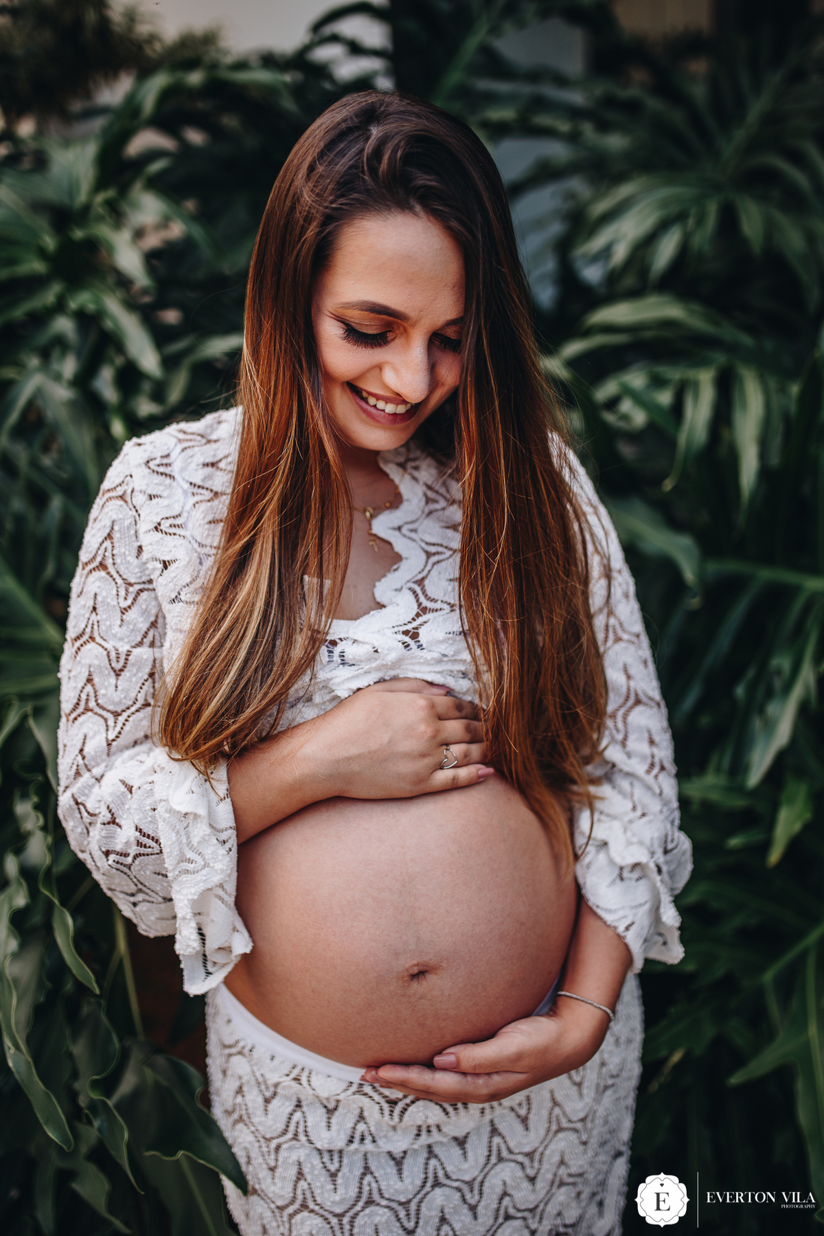 gestante feliz com a mão na barriga em ensaio fotográfico